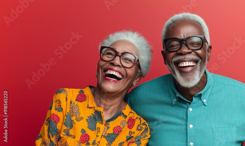 Smiling black senior couple, isolated red color background, image with space for text