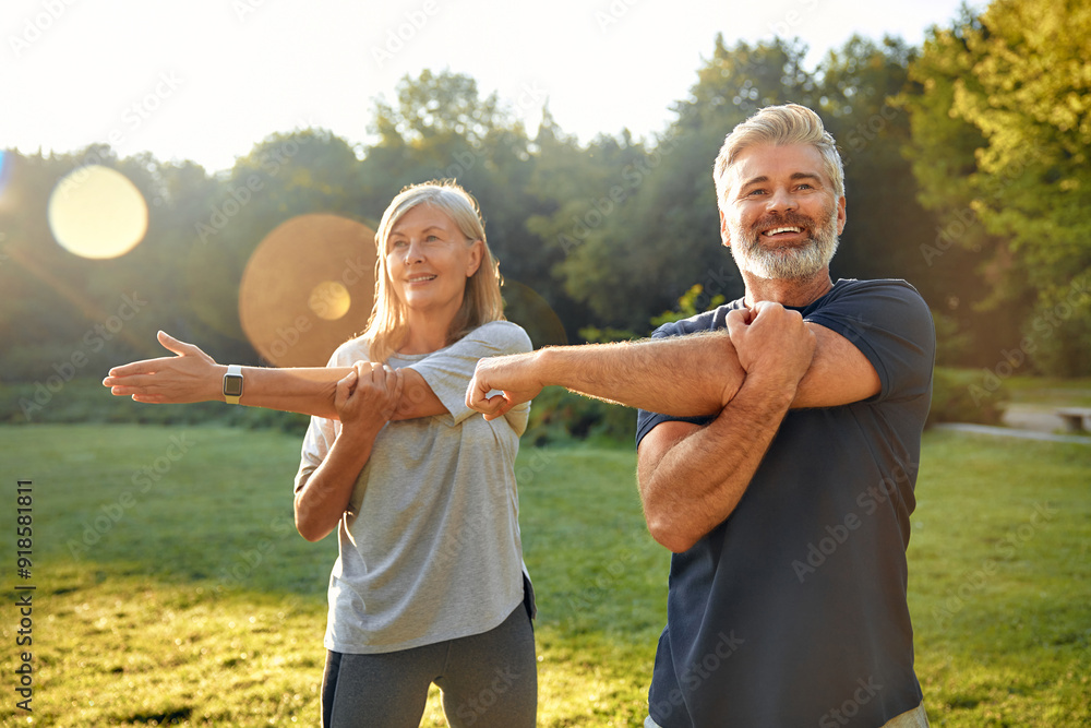 A Couple Engaging in Physical Exercises Together in the Bright Sunlit Park Setting A Couple Engaging in Physical Exercises Together in the Bright Sunlit Park Setting