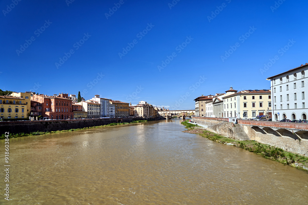 Fototapeta premium Bridge, tenement houses and historic buildings over the Arno river in the city of Florence