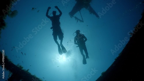 Wallpaper Mural Low angle shot of two scuba divers swimming over a shipwreck in Malta silhouetted by the sun Torontodigital.ca