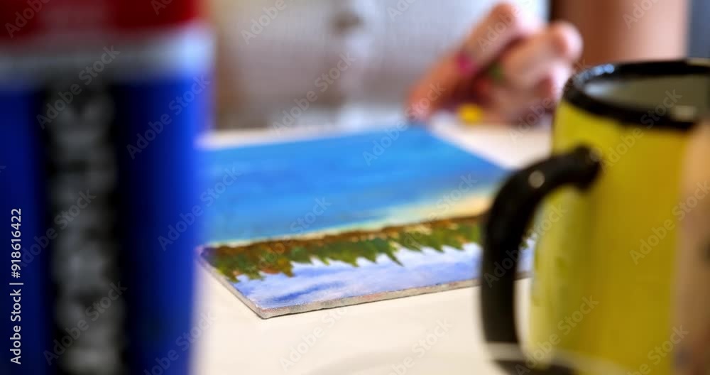 A close-up of a female painter demonstrating her craftsmanship as she works on a canvas with various colors of paint and brushes A close-up of a female painter demonstrating her craftsmanship as she works on a canvas with various colors of paint and brushes