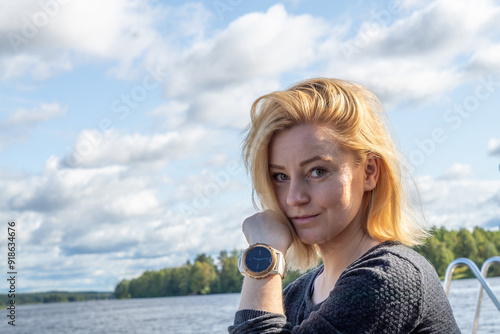 portrait of blonde woman at the pier in Rovaniemi Finland enjoying the nature photo