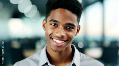 Confident young businessman smiling in modern office environment.