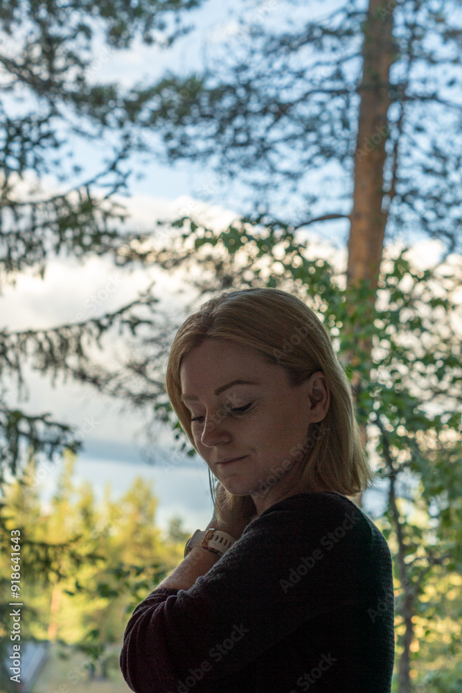 blonde woman looking through the window on the forest in Rovaniemi Finland in summer time blonde woman looking through the window on the forest in Rovaniemi Finland in summer time
