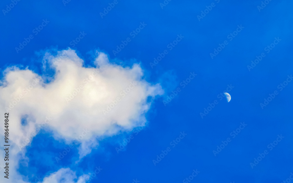 Crescent half full moon in blue sky during the day. Crescent half full moon in blue sky during the day.