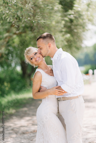 Happy Bride and Groom Embracing Outdoors on Their Wedding Day