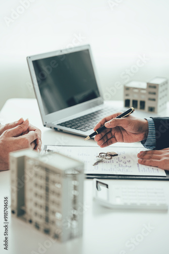 Fotografie Real estate agents dealing with the leasing of houses and condos are ready to negotiate and discuss the terms of the home purchase contract and ask customers to sign a contract to pay for the keys