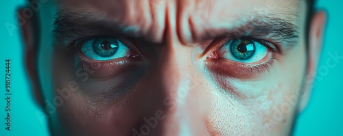 Close-up of an intense gaze with striking blue eyes, conveying deep emotion and focus against a vibrant background.