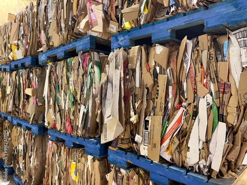 Photos Baled compacted cardboard boxes stacked on blue wooden pallets ready for recycli