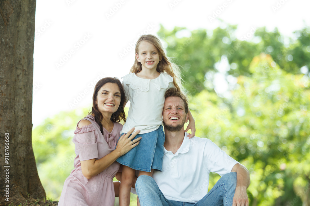Happy family relaxing together at the park, caucasian family with father, mother, and children walking at the park. Happy family relaxing together at the park, caucasian family with father, mother, and children walking at the park.