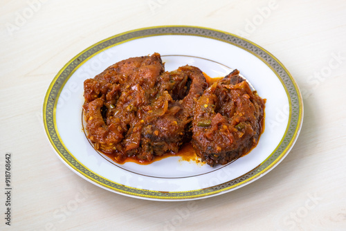 Obraz na plátně Delicious rui fish curry or rui mach bhuna in a white plate on light wooden surface