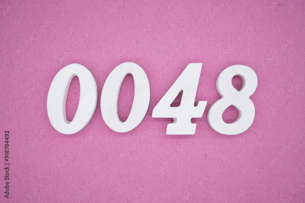 The numbers are made of white painted wood. Laying on the floor was pink paper. The numbers are made of white painted wood. Laying on the floor was pink paper.