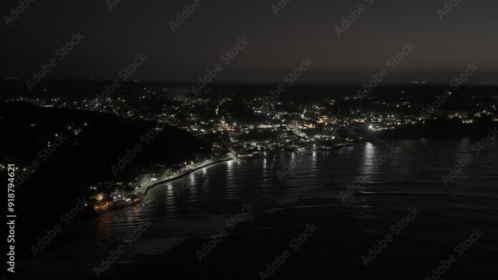 Drone flies from Atlantic Ocean toward the city center, at night in Pipa, Rio Grande do Norte, Brazil Drone flies from Atlantic Ocean toward the city center, at night in Pipa, Rio Grande do Norte, Brazil