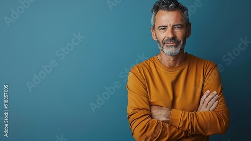 Handsome middleaged man standing with his arms folded looking at camera and smiling Halflength front portrait against blue background with copy space : Generative AI