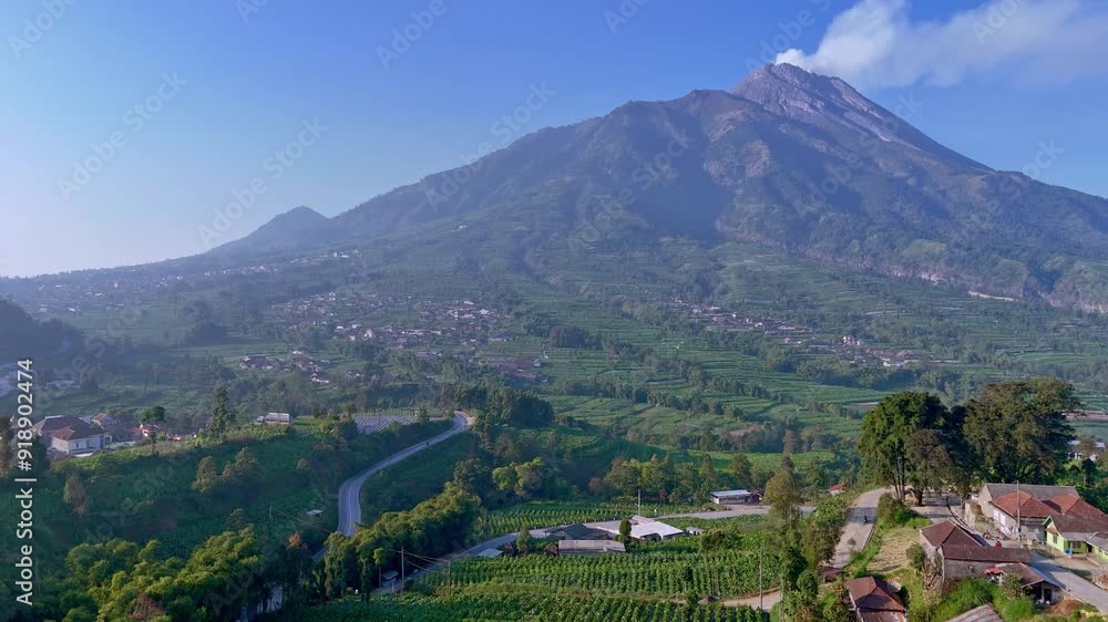 Aerial view of active volcano emits smoke and scenery of green tropical rural landscape. Indonesian countryside around Merapi Volcano. 4K drone footage. Aerial view of active volcano emits smoke and scenery of green tropical rural landscape. Indonesian countryside around Merapi Volcano. 4K drone footage.