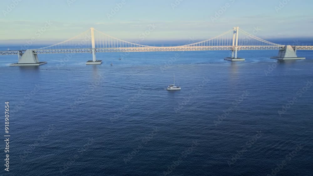 Cruise catamaran sails against the backdrop of a beautiful suspension bridge Gwangan at sunset. Cruise catamaran sails against the backdrop of a beautiful suspension bridge Gwangan at sunset.