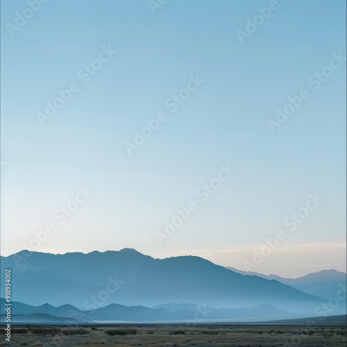 Silhouetted mountain range against a clear blue sky.