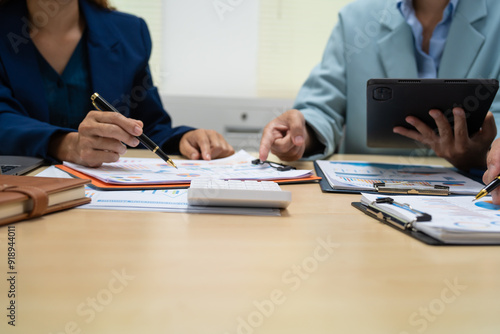 A businessperson financial analyst during a corporate meeting. review a graph document, discussing financial data and strategies to ensure successful outcomes effective teamwork achieving corporate