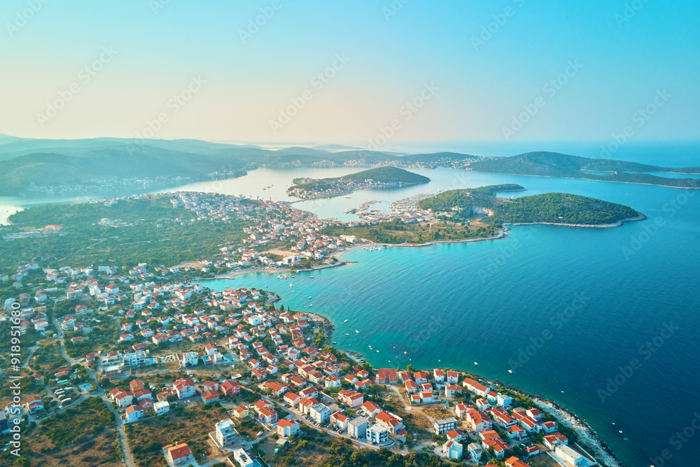 Aerial view of coastal town with colorful buildings near sea coastline. Touristic city for summer vacation with red roof houses and Islands in Adriatic sea. Panoramic view of Rogoznica town in Croatia Aerial view of coastal town with colorful buildings near sea coastline. Touristic city for summer vacation with red roof houses and Islands in Adriatic sea. Panoramic view of Rogoznica town in Croatia