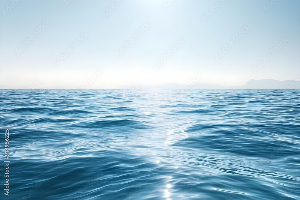 Obraz premium Calm blue ocean with gentle waves under a bright, clear sky. The smooth water surface creates a serene and tranquil atmosphere