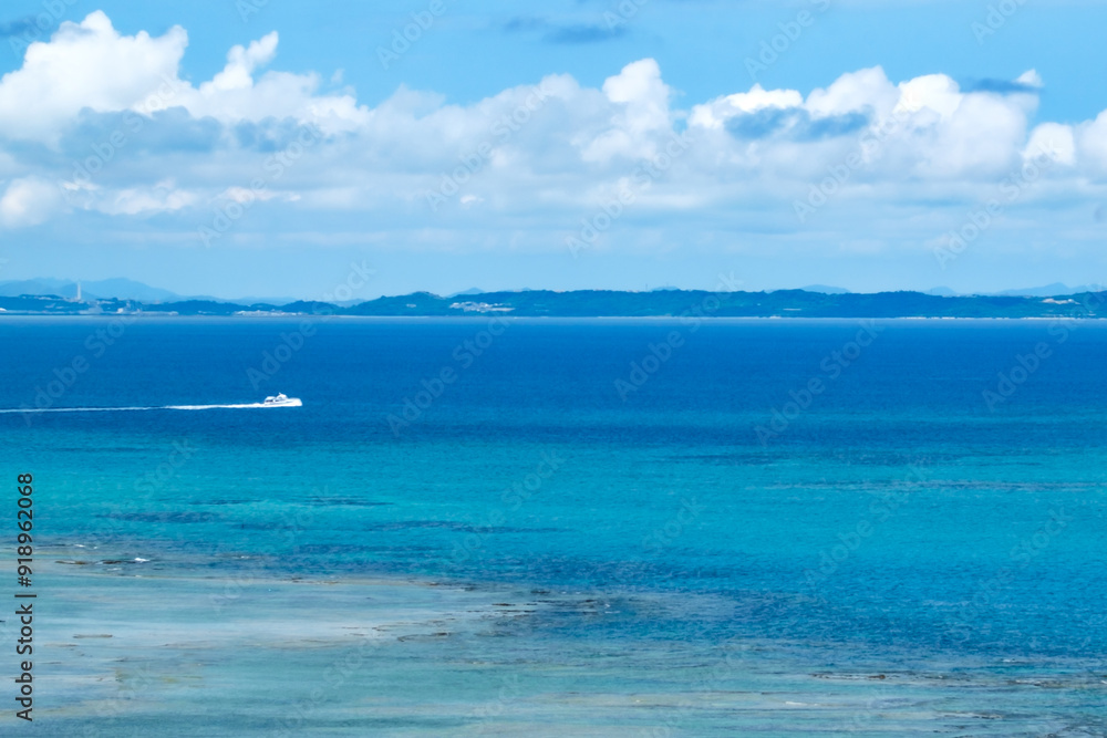 沖縄の青い海と海岸に打ち寄せる白い波、疾走するボート
沖縄の青い海と海岸に打ち寄せる白い波、疾走するボート