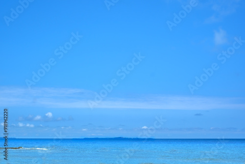 沖縄の青い海に浮かぶ平らな島影 