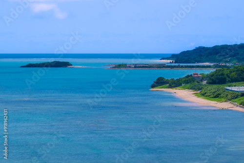 沖縄の青い海と岬に広がる小さな砂浜
