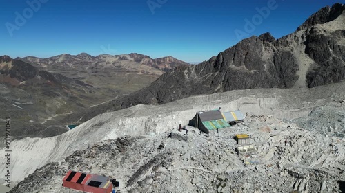 Aerial ascends from rustic base camp on rocky mountain slope, Bolivia photo