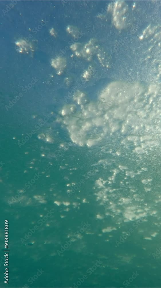 Vertical video, Camera moves forward under thin ice, Slow motion. Underwater view of ice. The movement of ice down the river in sunlight Vertical video, Camera moves forward under thin ice, Slow motion. Underwater view of ice. The movement of ice down the river in sunlight