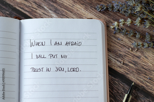 Photography Inspirational Christian quote to put your trust in the LORD when you are afraid handwritten in notebook placed on wooden table