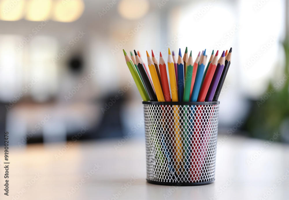Colorful pencils standing in a metal pencil holder on a blurred background Colorful pencils standing in a metal pencil holder on a blurred background
