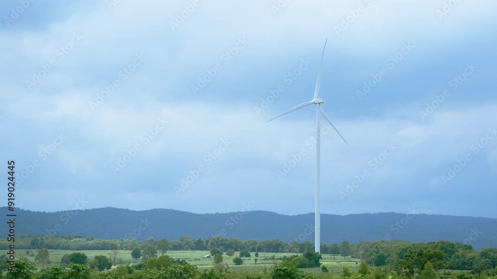 wind turbines stand tall in the landscape of rural area on the mountain for generating electricity, sustainable energy solutions and green energy concept. horizontal footage wind turbines stand tall in the landscape of rural area on the mountain for generating electricity, sustainable energy solutions and green energy concept. horizontal footage