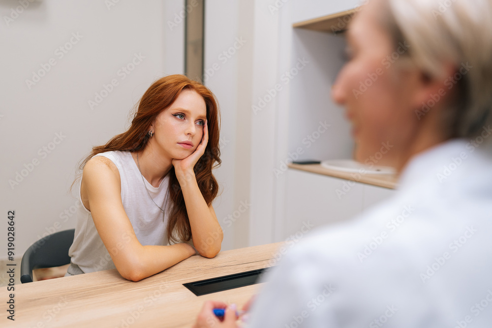 Portrait of tired stressed young woman patient telling doctor about pains and severe headaches. Physician listening to female patient complaining about migraine, high blood pressure, stress. Portrait of tired stressed young woman patient telling doctor about pains and severe headaches. Physician listening to female patient complaining about migraine, high blood pressure, stress.