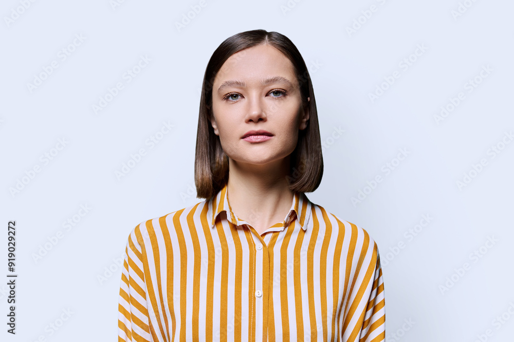 Portrait of young serious woman looking at camera on white background Portrait of young serious woman looking at camera on white background