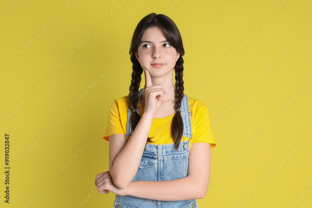 Portrait of cute teenage girl on yellow background Portrait of cute teenage girl on yellow background