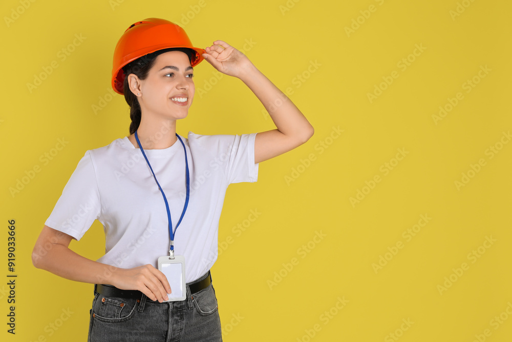 Engineer in hard hat on yellow background, space for text Engineer in hard hat on yellow background, space for text