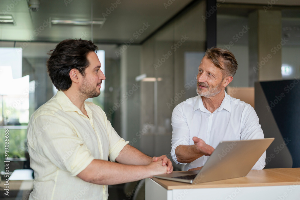 Senior businessman explaining colleague in meeting at office Senior businessman explaining colleague in meeting at office