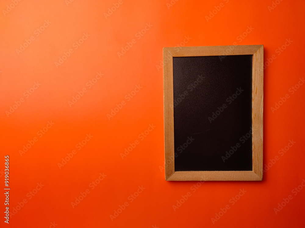 Top view black wooden board on a orange background Top view black wooden board on a orange background