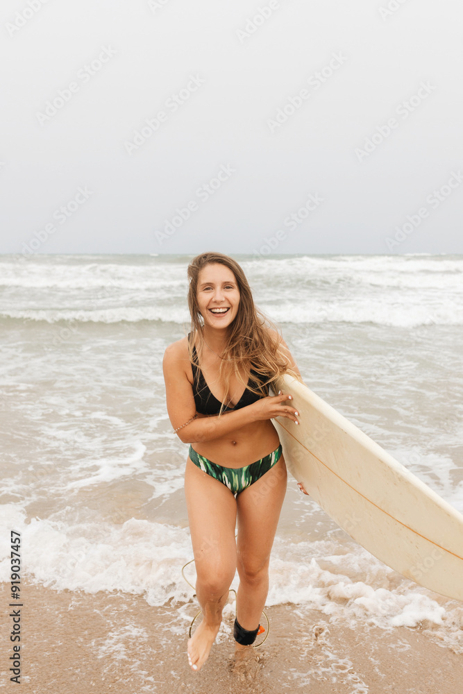 Smiling surfer with surfboard on sea shore Smiling surfer with surfboard on sea shore