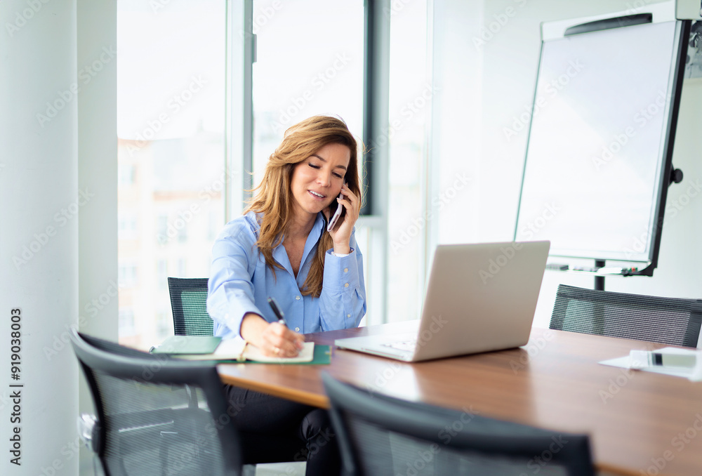 Businesswoman with laptop and smartphone sitting in a modern office and working Businesswoman with laptop and smartphone sitting in a modern office and working