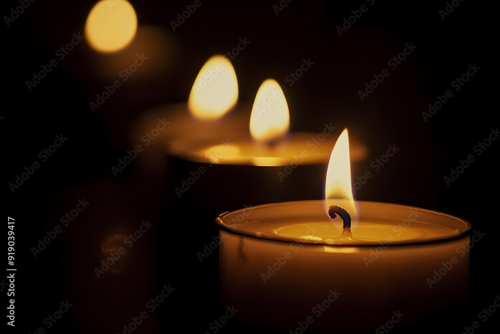 Lit candles in dark room creating warm and serene atmosphere. Soft glow of flames adds sense of calm and tranquility Lit candles in dark room creating warm and serene atmosphere. Soft glow of flames adds sense of calm and tranquility