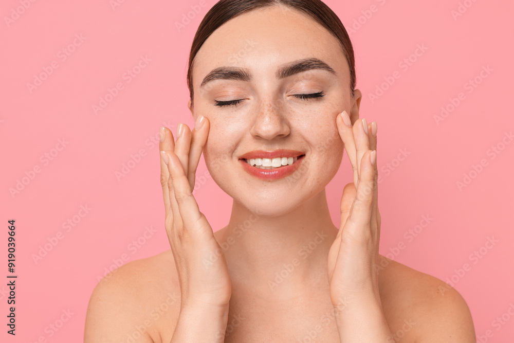 Beautiful young woman doing facial massage on pink background Beautiful young woman doing facial massage on pink background