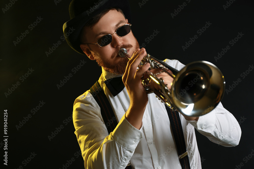 Obraz premium Professional musician playing trumpet on black background in color lights