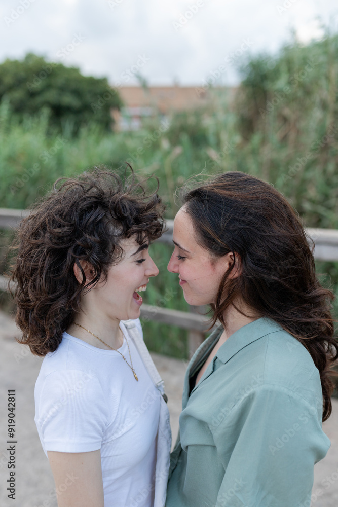 Lesbian couple interacting on bridge in daytime Lesbian couple interacting on bridge in daytime