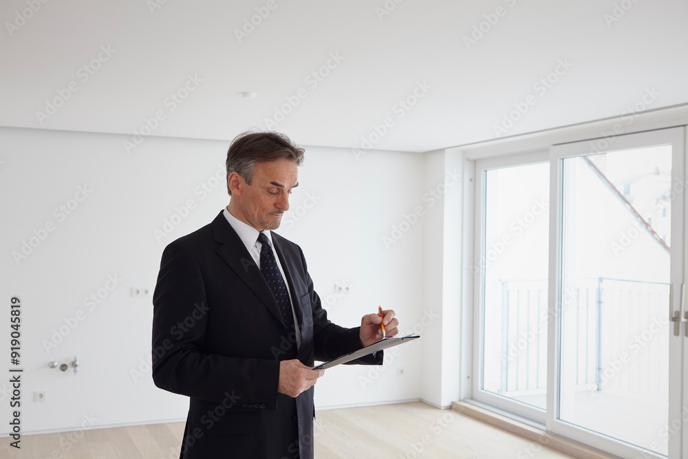 Businessman working on file in empty apartment Businessman working on file in empty apartment