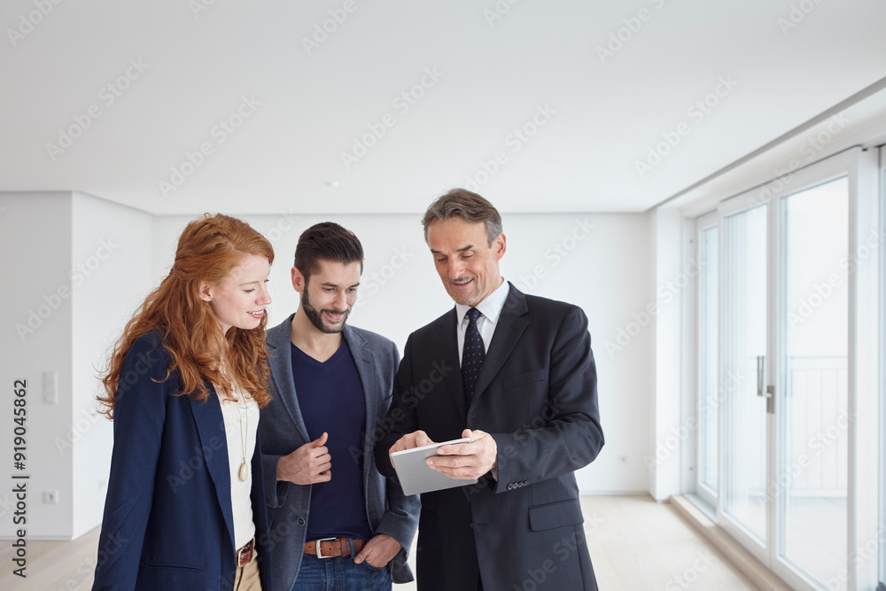 Real estate agent teaching couple to use automated system on tablet PC Real estate agent teaching couple to use automated system on tablet PC