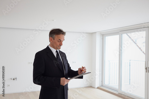 Businessman working on file in empty apartment