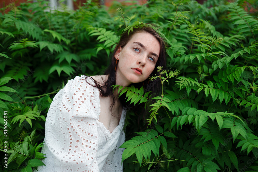 Teenage girl surrounded by leaves in garden Teenage girl surrounded by leaves in garden
