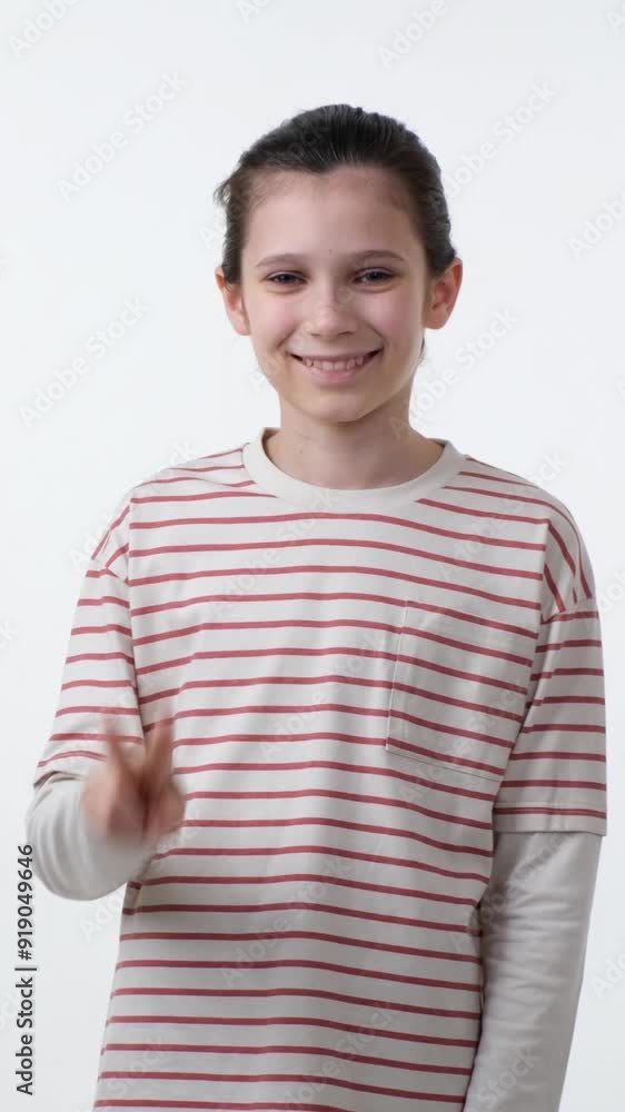 Happy and positive Caucasian teen boy showing victory or peace sign, standing on white background. Concept of a achievement, triumph, accomplishment. Vertical video. Happy and positive Caucasian teen boy showing victory or peace sign, standing on white background. Concept of a achievement, triumph, accomplishment. Vertical video.