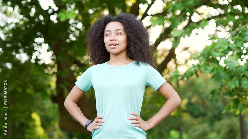 Happy young african american sportswoman resting after workout with closed eyes standing in urban city park. Smiling beautiful fit black woman breathes deeply, feels relief and enjoys being in nature Happy young african american sportswoman resting after workout with closed eyes standing in urban city park. Smiling beautiful fit black woman breathes deeply, feels relief and enjoys being in nature